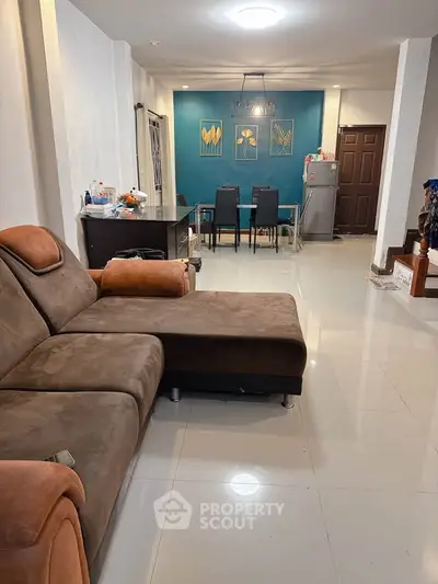 Spacious living room with modern decor and dining area, perfect for family gatherings.