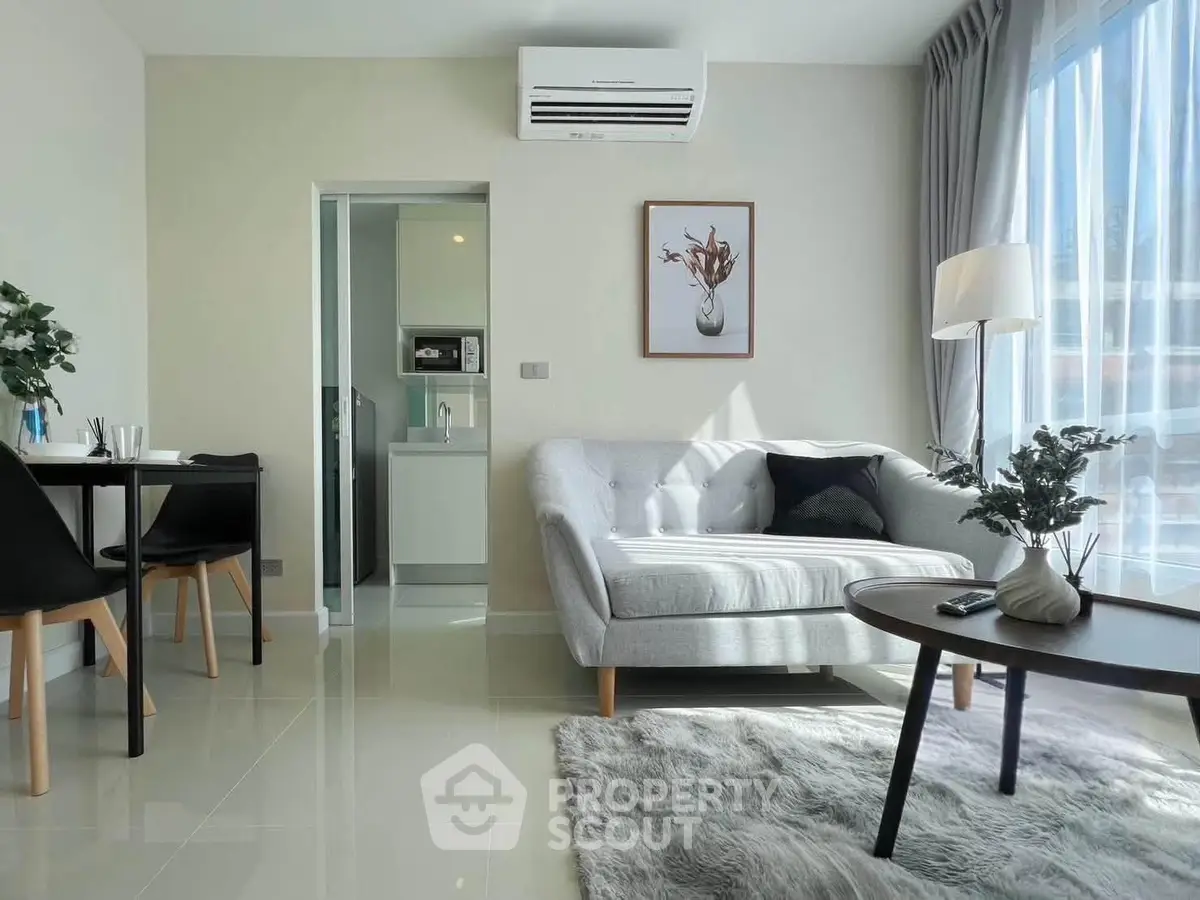 Modern living room with cozy sofa, stylish decor, and natural light in a contemporary apartment.