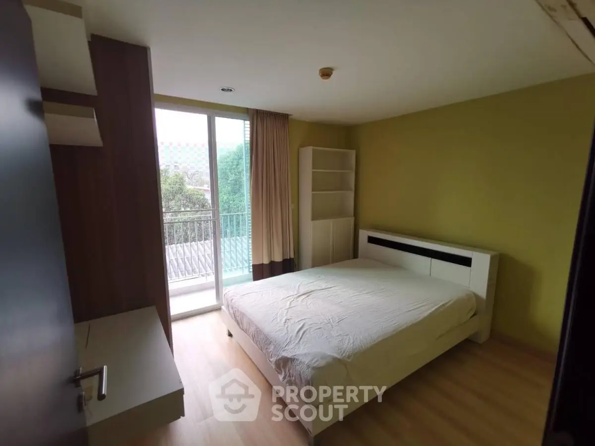 Spacious bedroom with balcony access and natural light in modern apartment.