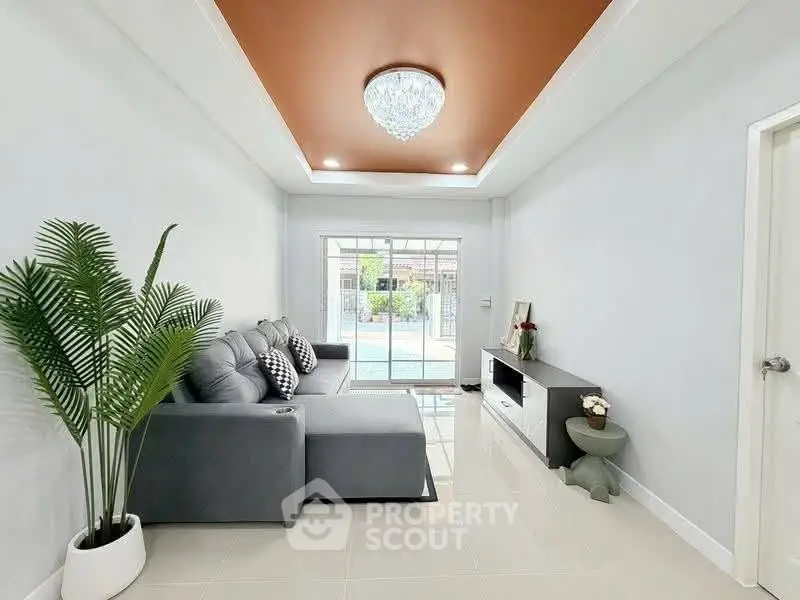 Modern living room with elegant decor and pool view, featuring a stylish sofa and chic lighting.
