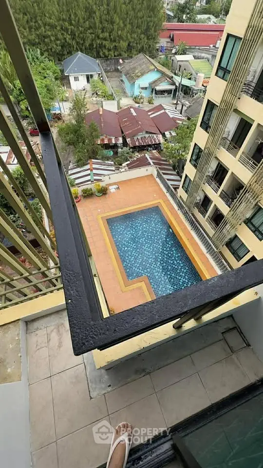 Stunning aerial view of a modern apartment building with a refreshing pool and lush greenery.
