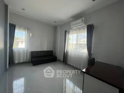 Spacious living room with modern sofa and large windows for natural light.