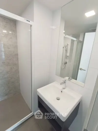 Modern bathroom with sleek sink and glass shower enclosure