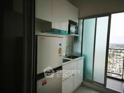 Modern kitchen with sleek appliances and balcony view in high-rise apartment