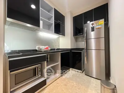 Modern kitchen with sleek black cabinets and stainless steel appliances
