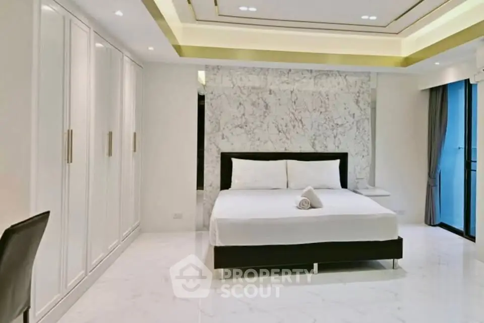 Luxurious modern bedroom with marble accent wall and sleek design