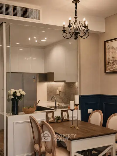 Elegant dining area with chandelier and modern kitchen in open layout