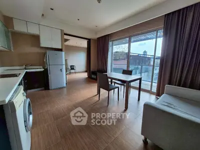 Modern open-plan living room with kitchen and balcony view