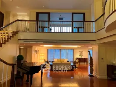 Luxurious living room with grand piano and elegant decor in spacious two-story home.