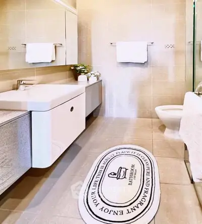 Modern bathroom with sleek fixtures and stylish decor, featuring a large mirror and elegant vanity.