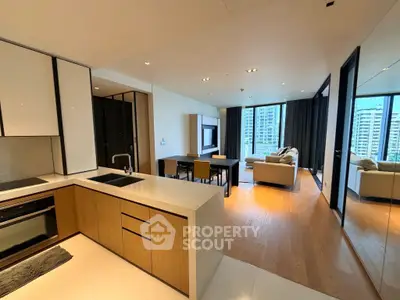 Modern open-plan living room with kitchen, featuring sleek design and city view.