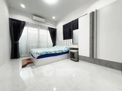 Modern minimalist bedroom with sleek design and ample natural light.