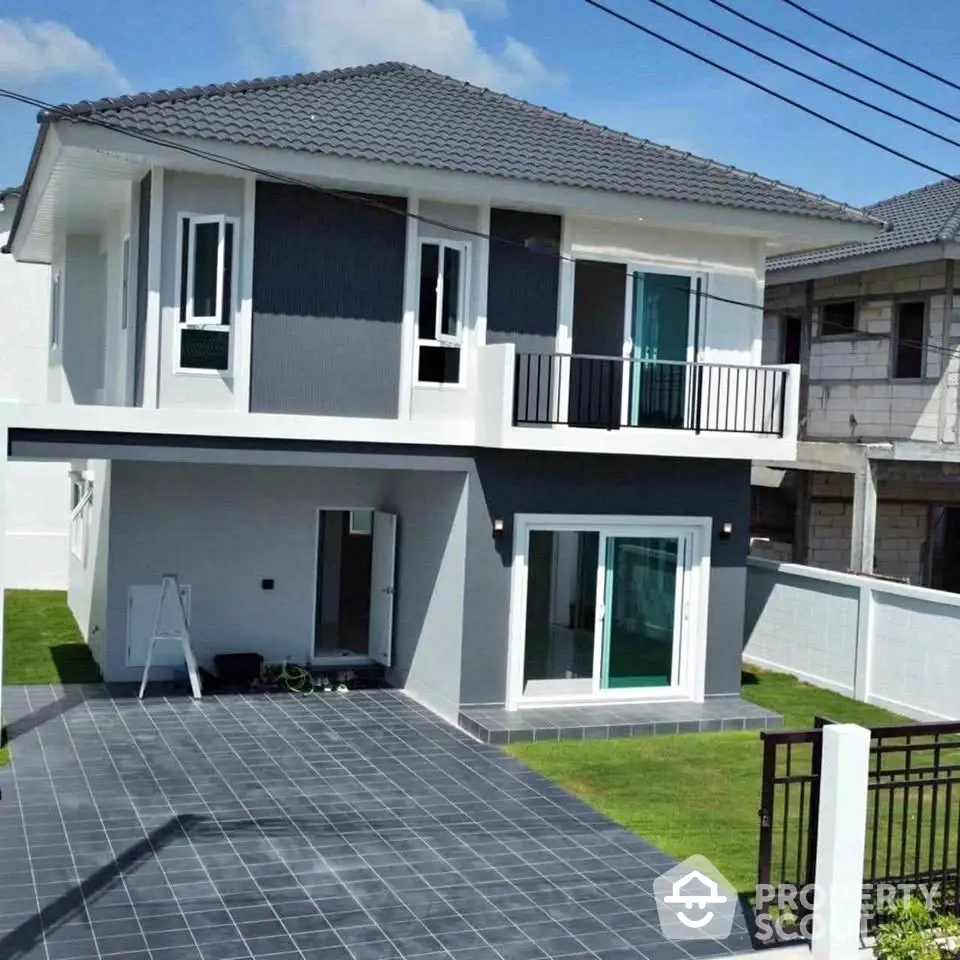 Modern two-story house with sleek design and spacious driveway in a suburban neighborhood.