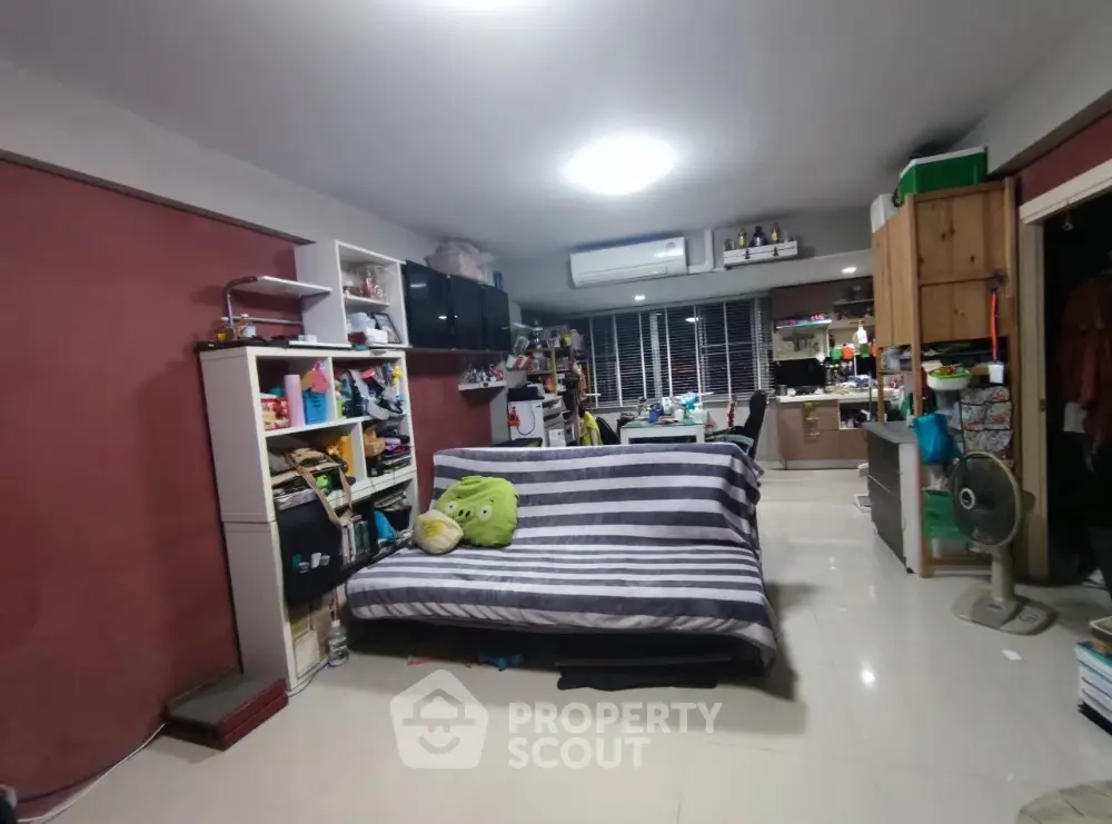 Cozy living room with striped sofa and open kitchen layout, perfect for modern living.