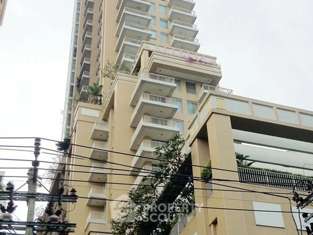 Modern high-rise building with multiple balconies and urban view.