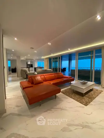 Luxurious open-plan living room with modern furniture and stunning ocean view.