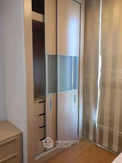 Modern bedroom with sleek built-in wardrobe and elegant wooden flooring.