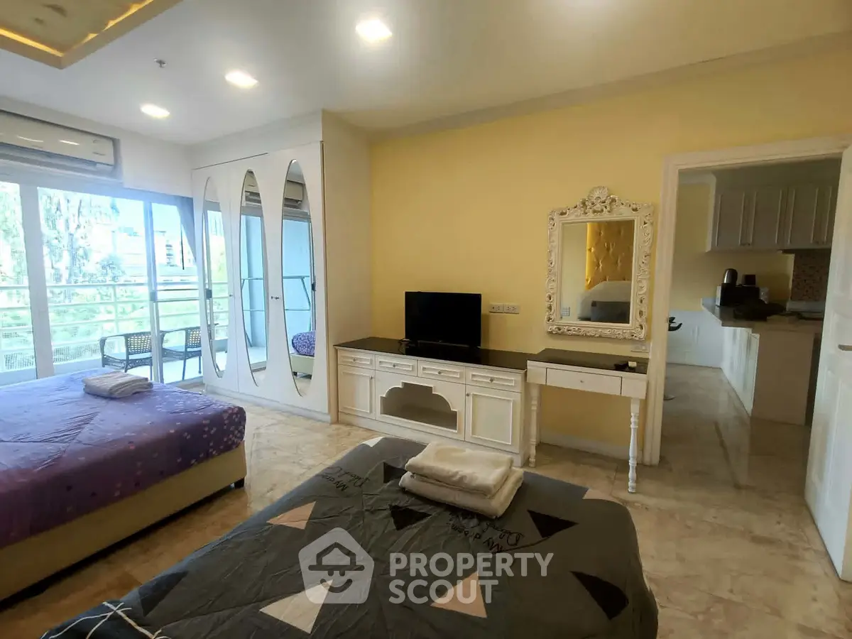 Spacious bedroom with balcony access and elegant decor in modern apartment