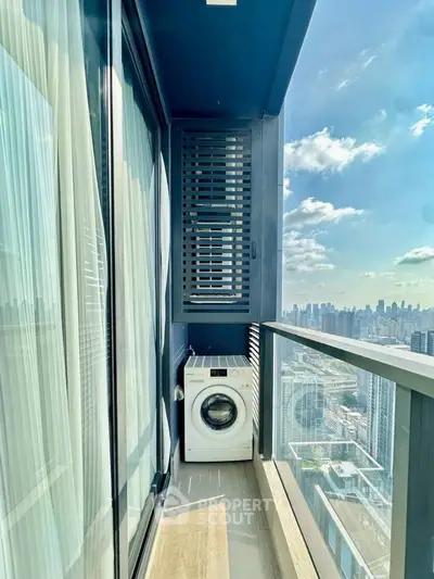 Stunning high-rise balcony with cityscape view and washing machine setup.