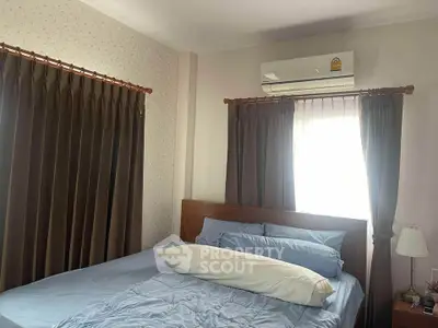 Cozy bedroom with air conditioning and elegant curtains, perfect for relaxation.