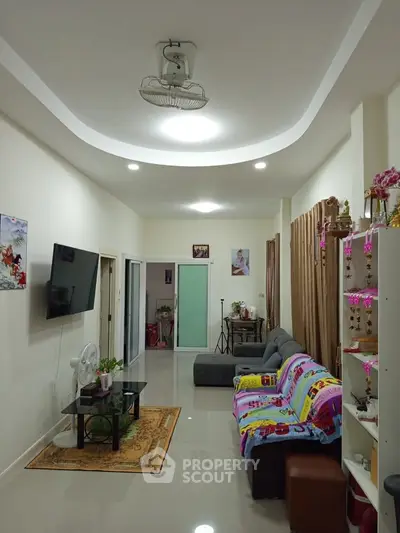 Spacious living room with modern decor and cozy seating area, perfect for relaxation and entertainment.