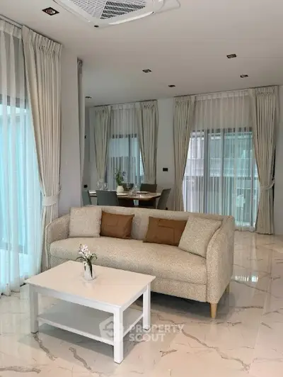 Elegant living room with modern decor and large windows in a luxury apartment.