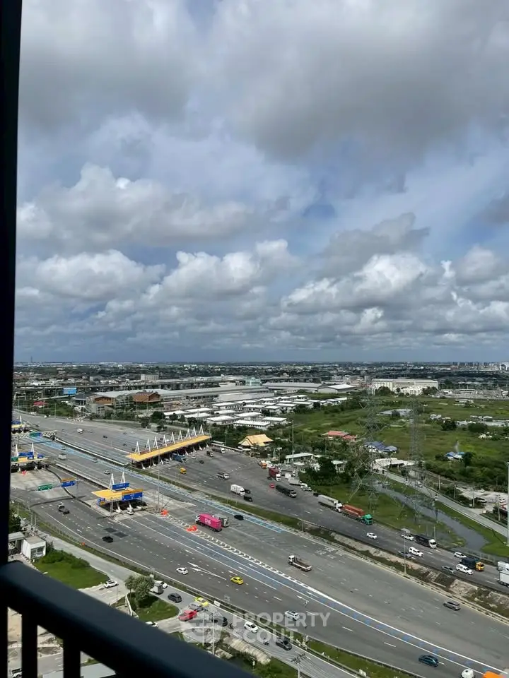 Stunning cityscape view from a high-rise balcony overlooking a busy highway and expansive skyline.