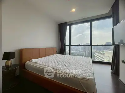 Modern bedroom with large windows offering stunning city views