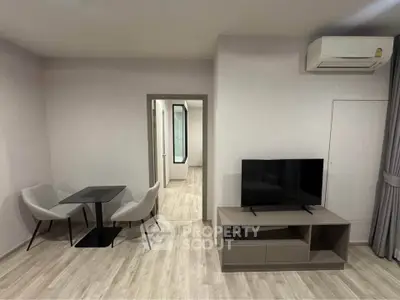 Modern living room with sleek furniture and air conditioning, featuring a minimalist design and neutral tones.