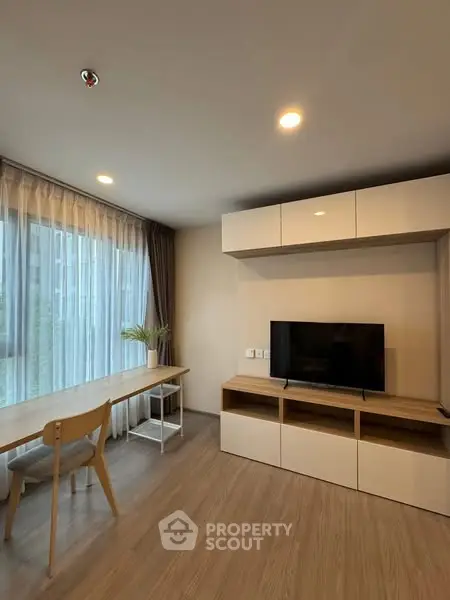 Modern living room with sleek furniture and large window, perfect for urban living.