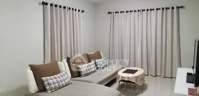 Cozy living room with modern sofa and elegant curtains, perfect for relaxation.