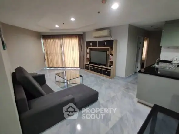 Spacious modern living room with sleek furniture and large windows.