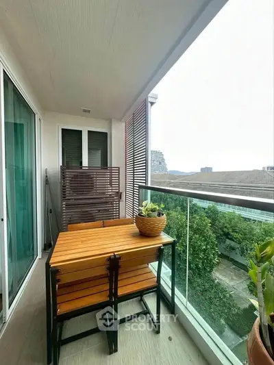 Charming balcony with modern furniture and lush green view, perfect for relaxation and enjoying the outdoors.