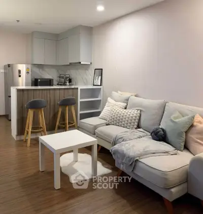 Modern living room with cozy sofa and stylish kitchen in open layout apartment.