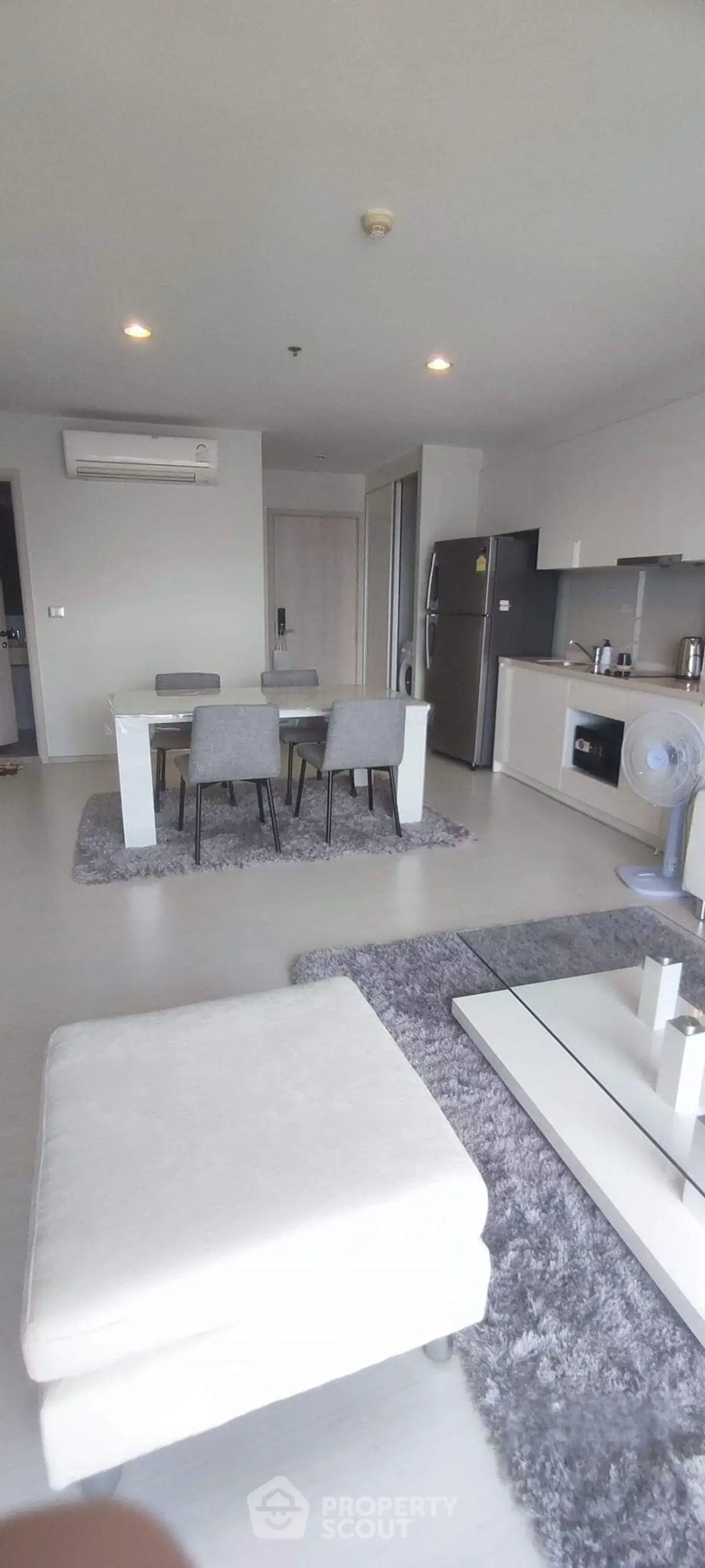 Modern open-plan living room with dining area and sleek kitchen appliances