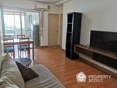 Modern living room with balcony access, featuring sleek furniture and hardwood flooring.