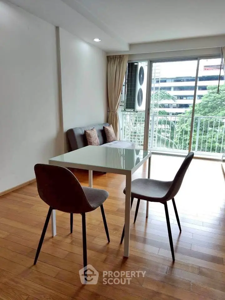 Bright living room with modern dining set and balcony view