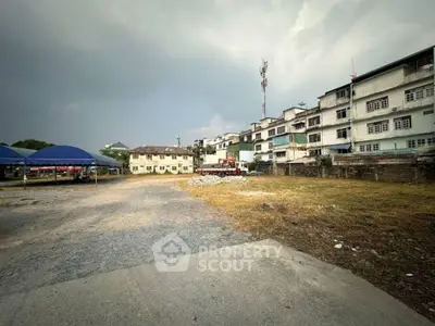 Spacious open land with potential for development near residential buildings.