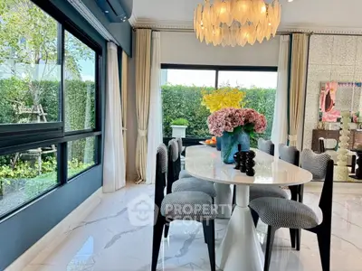 Elegant dining room with modern decor and large windows overlooking lush garden