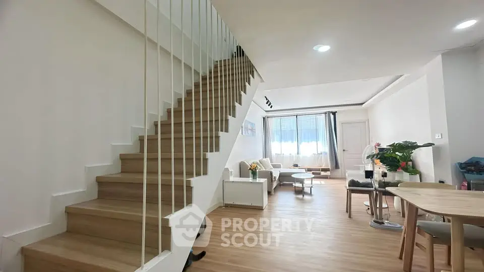 Spacious modern living room with wooden staircase and elegant decor