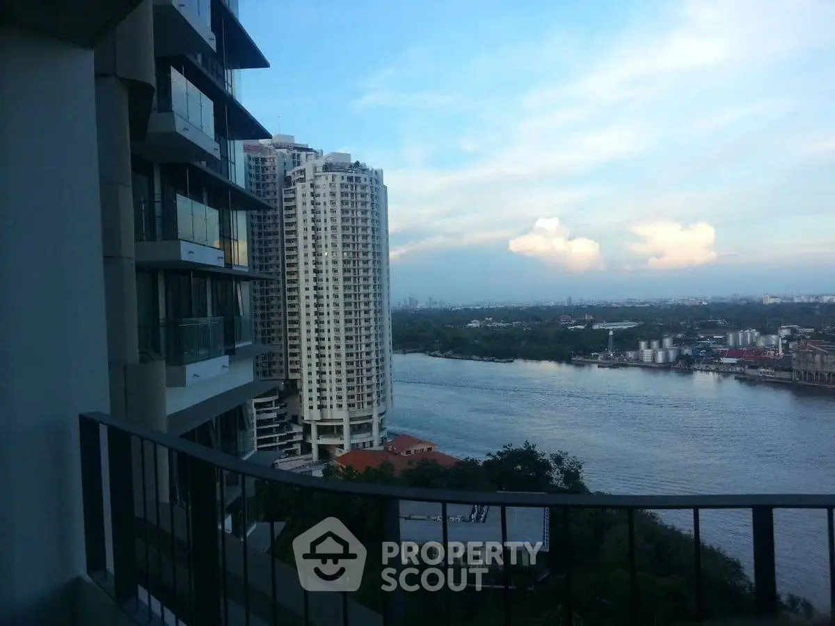 Stunning river view from high-rise balcony with city skyline in the distance.