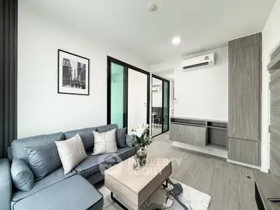 Modern living room with stylish decor and open layout, featuring a cozy sofa and sleek furniture.