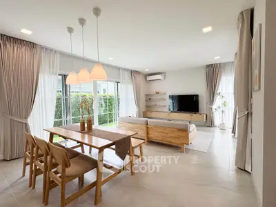 Spacious modern living room with elegant dining area and large windows for natural light.