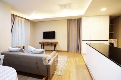 Modern living room with sleek design, featuring a cozy sofa, wall-mounted TV, and stylish wooden flooring.