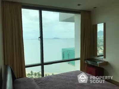 Luxurious bedroom with stunning ocean view and floor-to-ceiling windows in modern apartment.