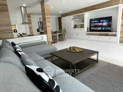 Spacious modern living room with sleek design and open layout, featuring a large sectional sofa and entertainment center.