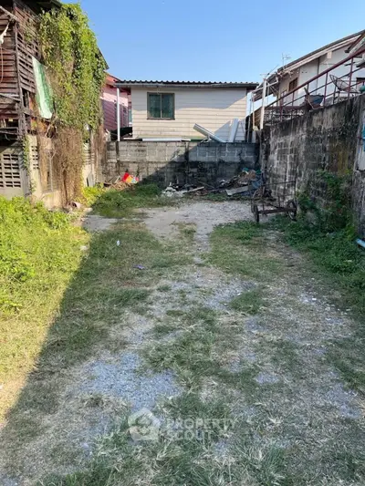 Vacant lot with potential for development in urban area, surrounded by residential buildings.