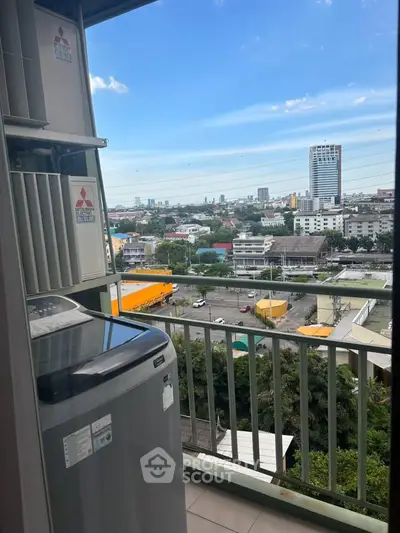 High-rise balcony with cityscape view and modern appliances, perfect for urban living.
