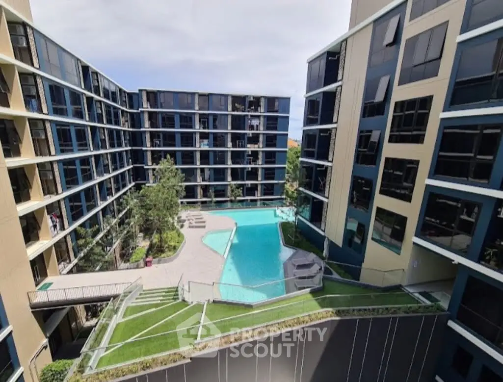 Modern apartment complex with central pool and landscaped garden