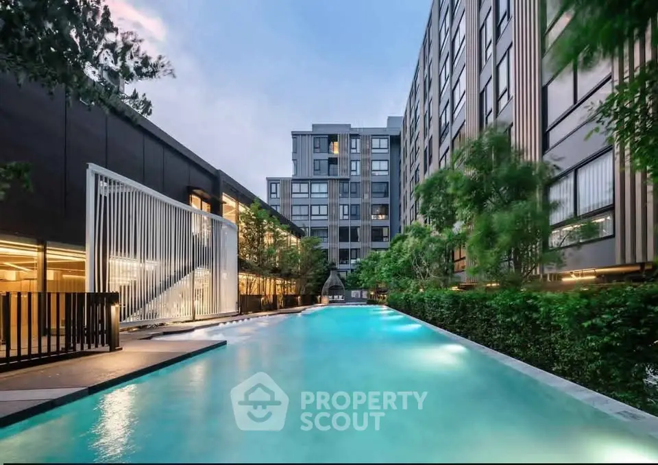 Luxurious modern apartment complex with stunning outdoor pool and lush greenery.
